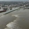Floodwaters surge across the top of a levee near New Orleans' Industrial Canal. The view is looking south to the Mississippi River. Credit: FEMA