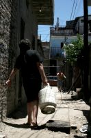 Woman carrying gas cylinder in Buenos Aires slum. Credit: Malena Bystrowicz/IPS.