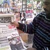 Newspaper vendor Md. Rafiq holds up a local newspaper advertising TV coverage of the Obama inauguration. Credit: Beena Sarwar/IPS