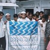 Impoverished weavers display a fine, silk Benarsi sari.  Credit: Bharat Dogra/IPS