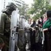 Women with their arms linked face off with riot police in Tehran on Jun. 22.  Credit: .faramarz/flickr/creative commons