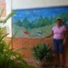 Eduarda Román next to a mural of the Laguna de Tacarigua at her house. - Humberto Márquez/IPS